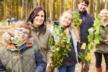 Familie und Kinder mit Baum Setzlingen zur Aufforstung