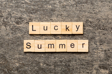 Fototapeta premium lucky Summer word written on wood block. lucky Summer text on cement table for your desing, concept