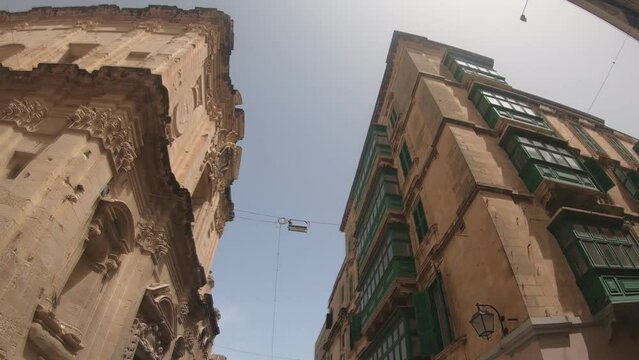 Looking Up Walking Past Buildings with Maltese Balconies in Valletta, the Capital of Malta. Slow Motion Handheld Footage.