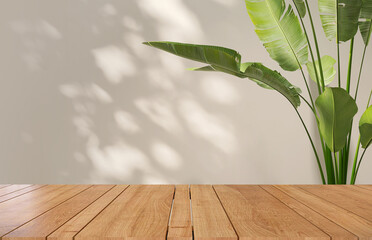 Wooden table counter top with beige wall and tropical banana plant in background with sunlight and...