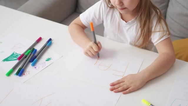 Foreign education. Inspired girl. Creative lesson. Shy female kid drawing word family with orange marker then hiding under desk light room interior.
