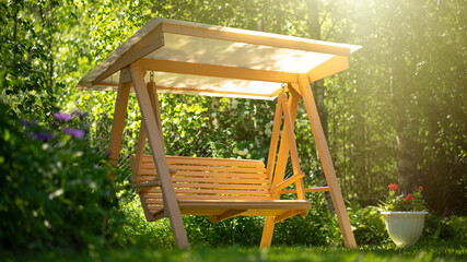 Wooden garden swing stands on the green grass in the garden. A place for privacy with nature. Relax in the fresh air. Rest on the swing. Garden furniture with your own hands. © Svetliy