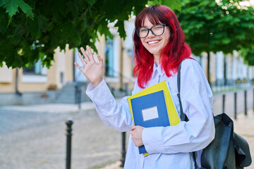 Portrait of smiling female student 18, 19 years old on city street