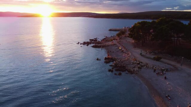 Aerial view of rocky Croatian island beach at sunset on Adriatic sea Krk island Punat Medane beach