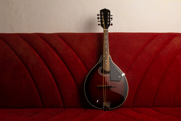 Mandolin resting on an old red sofa