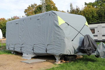 a caravan with a gray tarpaulin