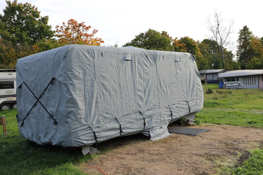 a caravan with a gray tarpaulin