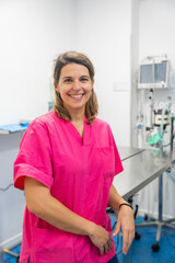 Portrait of a young female veterinarian at the vet clinic, smiling in uniform