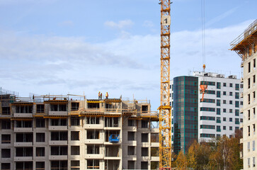 Fototapeta na wymiar Budowa apartamentowca w Katowicach dźwigi budowlane i elewacja podczas budowy na tle błękitnego nieba