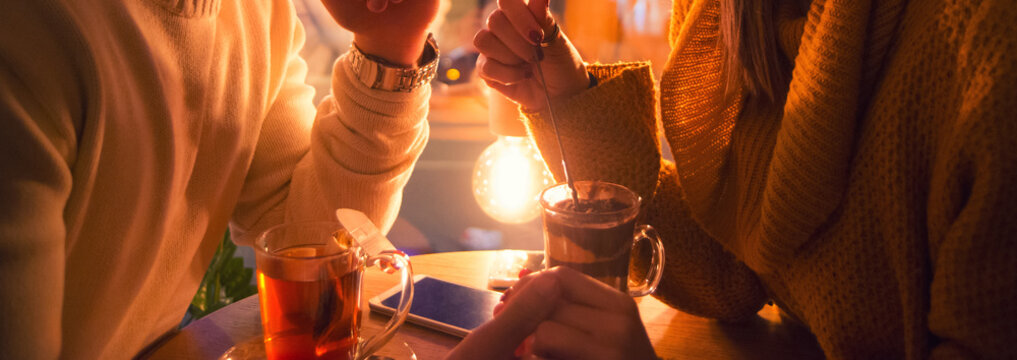 Young Couple In Love Sitting In The Coffee Bar, Drinking Tea And Eating Chocolate Cream