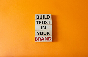 Build trust in your brand symbol. Wooden blocks with words Build trust in your brand. Beautiful orange background. Business and Build trust in your brand concept. Copy space.