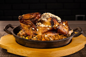 Whole roasted chicken with vegetables, on wooden table,