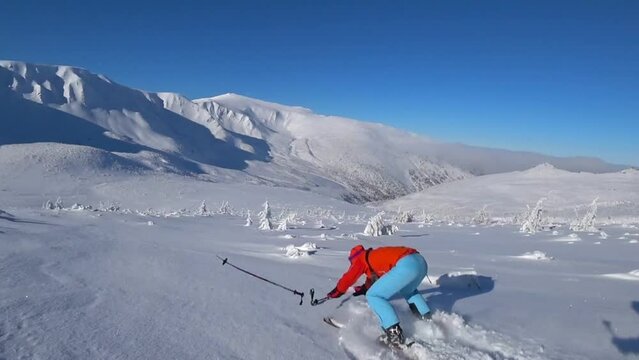 Skier falling down, follow shot. Freeride skiing . Bright sun, cold winter weather