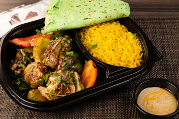top view of an Egyptian meal consists of rice , chicken , salad , bread and vegetables