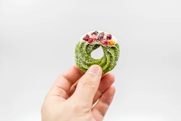 Gordijnen Person's hand holding a round Christmas cookie against a white background © Lv Shangyuan/Wirestock Creators