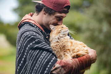 Young man interacting with ginger pet cat