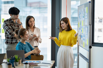 A group of young modern Asians in smart casual wear are having a brainstorming meeting while...