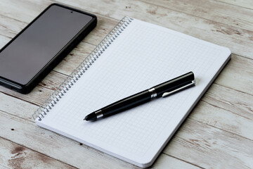 Smartphone, pen and blank notebook - concept, goals and action plan, new year