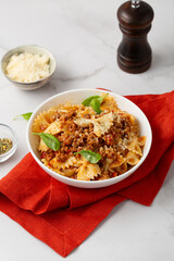 Close up of bolognese italian pasta cheese basil in white bowl