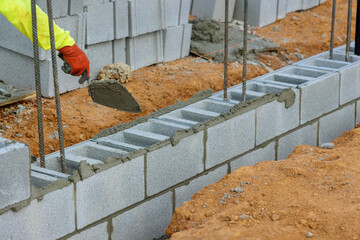 Bricklayer mason, is laying mounting for wall of concrete blocks that will be used as part building project