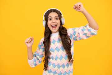 Obraz na płótnie Canvas Excited face. Funny kid girl 12, 13, 14 years old listen music with headphones. Teenage girl with headphones listening songs on headset earphone. Amazed expression, cheerful and glad.
