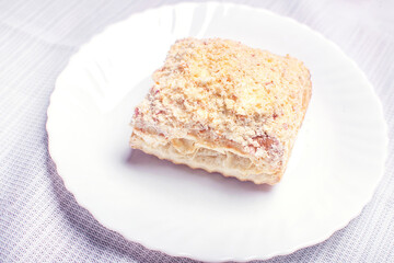 Close up of millefeuille in a white plate. Homemade sweet cake napoleon. Puff dessert.