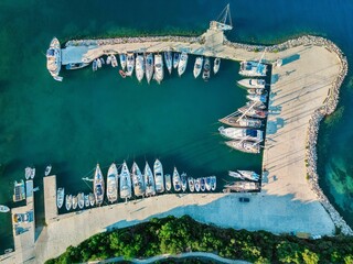 Aerial view of row of sailboats around the concrete dock at the marina in Syvota, Greece