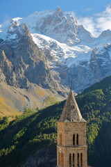 Fototapeta na wymiar The Meije Peak viewed from Les Terrasses village in Ecrins National Park, Romanche Valley, Hautes Alpes (French Southern Alps), France, with the bell tower of the church in the foreground