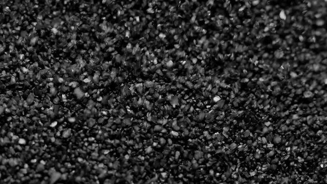 Black sand moving. Close-up of a black sand surface moving.