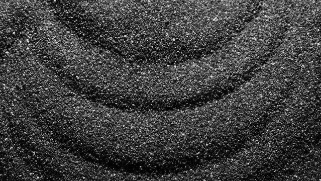Black sand moving. Close-up of a black sand surface moving.