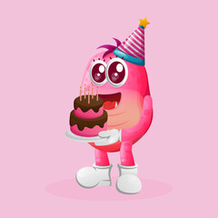Cute pink monster wearing a birthday hat, holding birthday cakev
