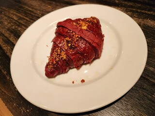 Red velvet croissant bread on a white plate.