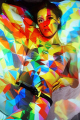 Colourful projection from beamer or slide projector onto young woman