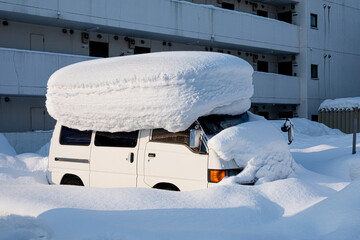 雪に押しつぶされそうな車 北海道札幌市 - obrazy, fototapety, plakaty