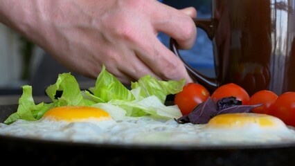 For breakfast, delicious scrambled eggs with vegetables and fresh tomatoes. Breakfast on a keto diet is rich in fats and proteins. Fresh cherry tomatoes are added to the scrambled eggs to add flavor.
