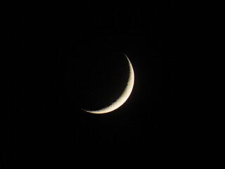 Naklejka na ściany i meble The crescent moon gleams against the midnight sky, its delicate curves a symbol of mystery and beauty