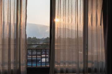 Views from inside the rooms through the curtains that cover the window panes outward offer views of the mountains and the rising sun in the summer after a restful night.