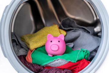 Concept of saving electricity with a washing machine with a piggy bank inside