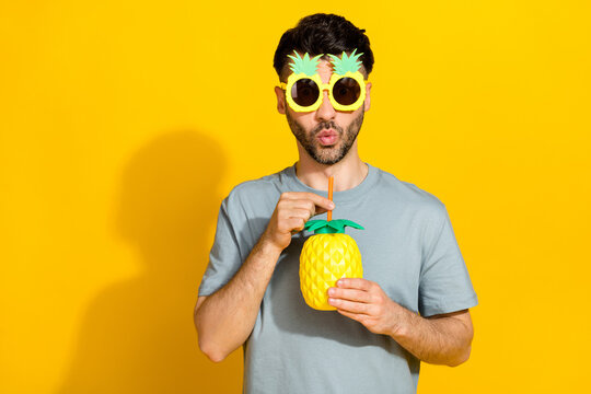 Photo of young relaxed chill brunet funky guy student rest after working every day wear summer pineapple glasses drink fresh isolated on yellow color background