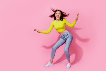 Photo of charming impressed lady wear yellow top air blowing dancing empty space isolated pink color background