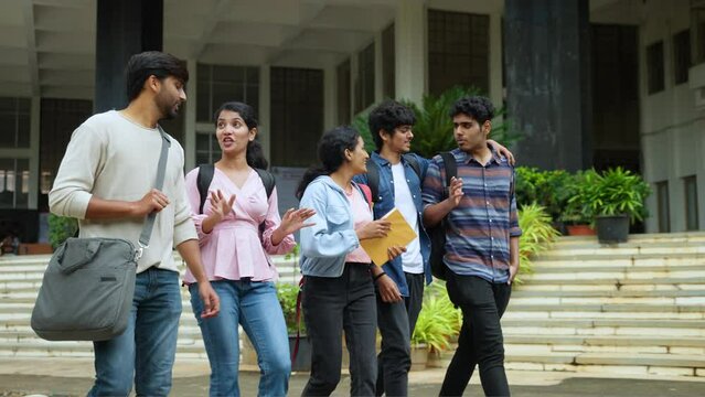 tracking shot, Group of happy students going home by talking each other after class at college campus - concept of friendship, enjoyment and millennial lifestyle.