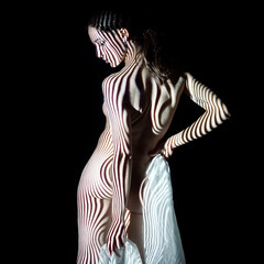 Projection with stripes from beamer or slide projector on young woman looks like body painting - obrazy, fototapety, plakaty