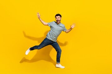 Fototapeta na wymiar Full length photo of active overjoyed young man dancing toothy smile isolated on yellow color background