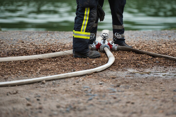 Firefighter operates a water manifold with hoses attached