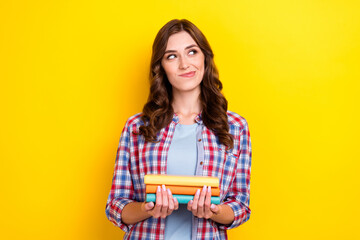 Portrait of curious cunning woman with curly hairstyle wear checkered shirt hold book look empty...