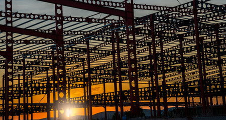 Cellular beam construction of industrial building structure on sunset in the evening