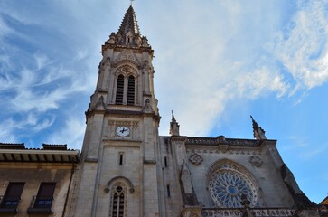 iglesia con torre y reloj con un cielo azul con alguna nube