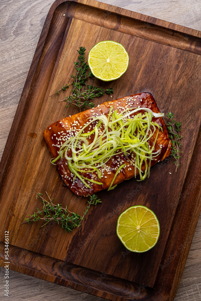 Wall mural salmon steak in grilled sauce on a wooden board