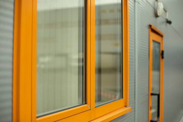 Orange window in building. Details of house. Industrial building.