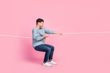 Profile side full body photo of determined guy leader fight tug war contest pull string isolated...